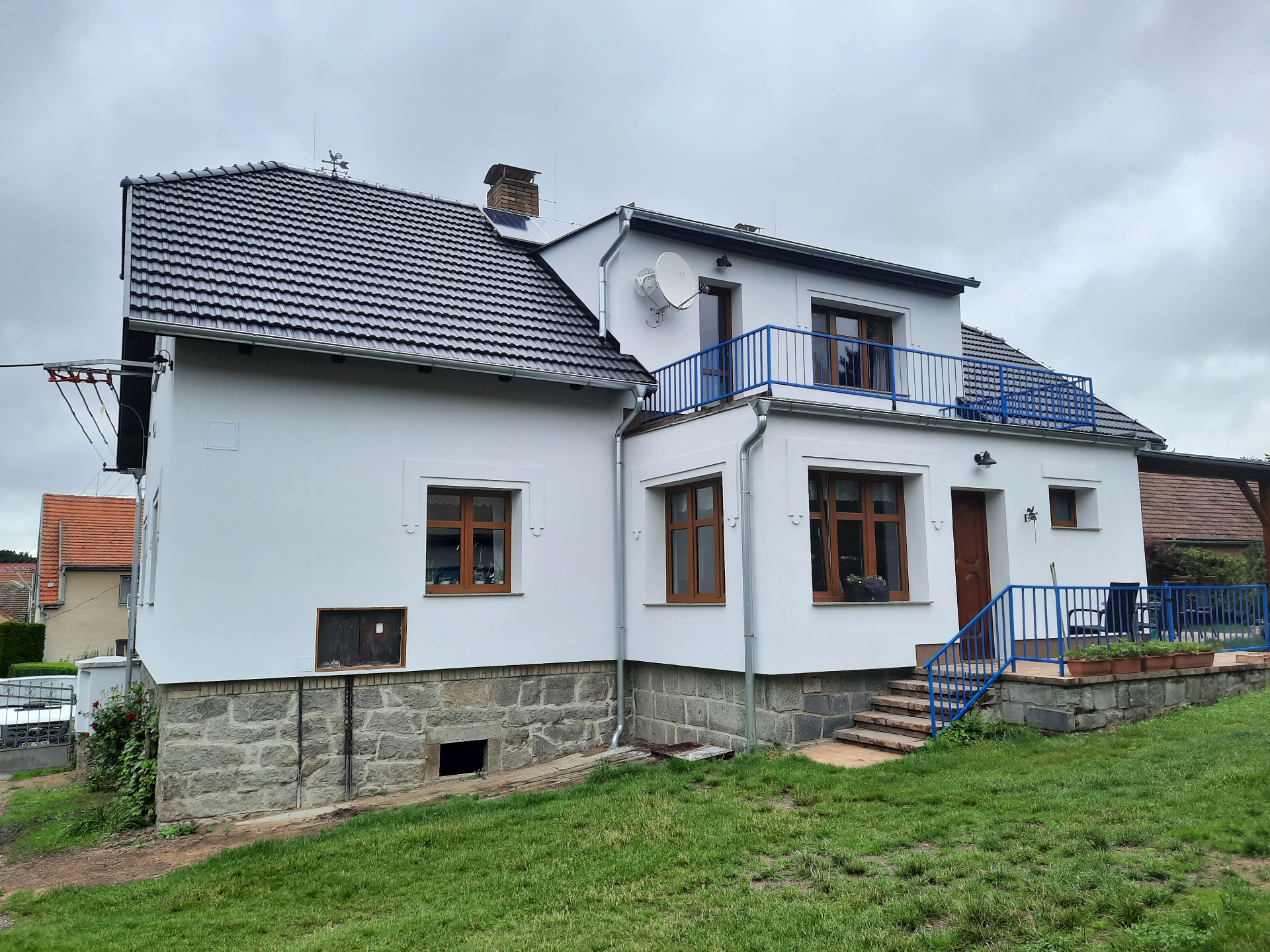 Fasáda s kamenným soklem a novou střechou, jižní Čechy